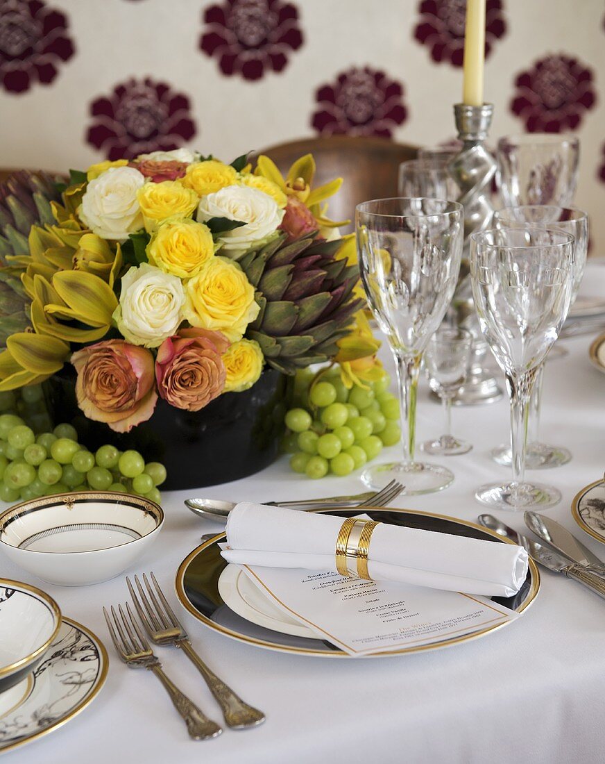 Festlich gedeckter Tisch mit Blumenstrauss und Menükarte