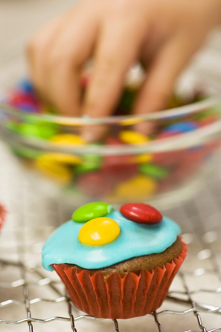 Schokoladen-Cupcake mit Schokolinsen verzieren