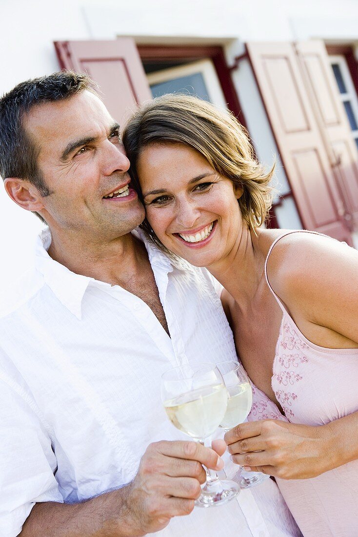 Mann und Frau stossen mit Weißwein an