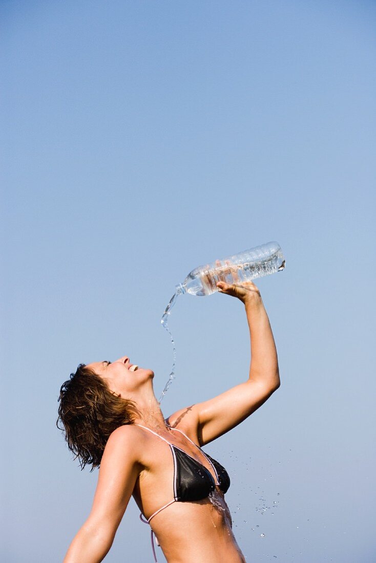 Junge Frau erfrischt sich mit Wasser