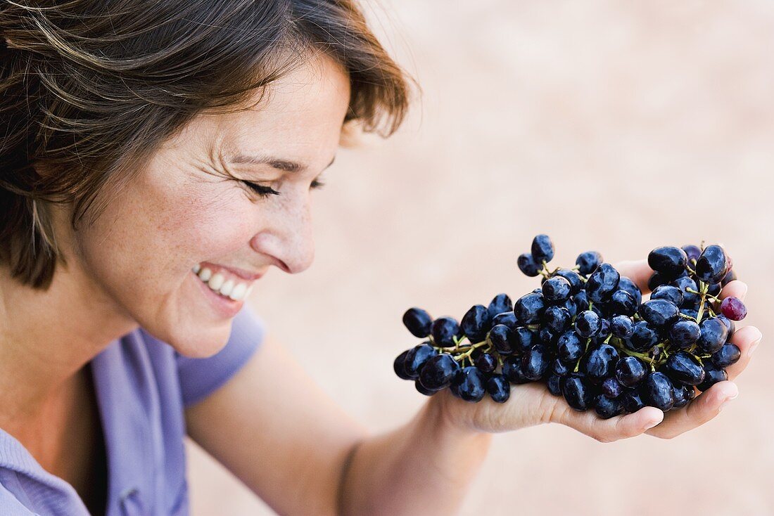 Woman with black grapes