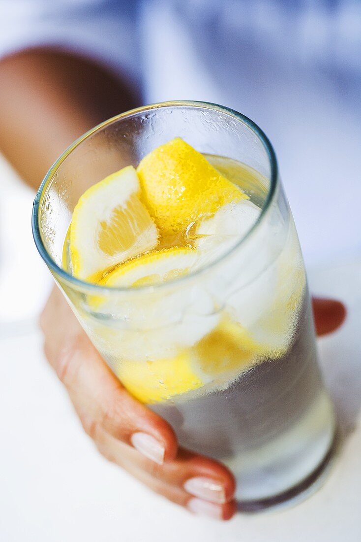 Hand holding a glass of lemonade