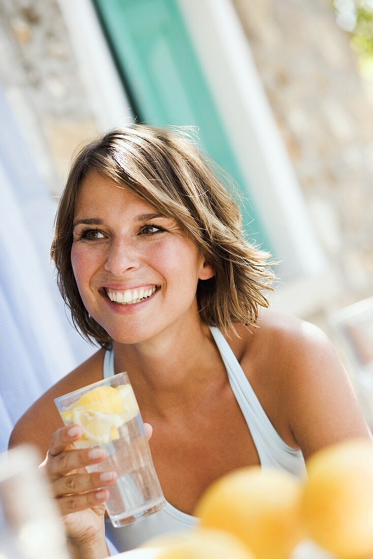 Junge Frau mit einem Glas Zitronenlimonade