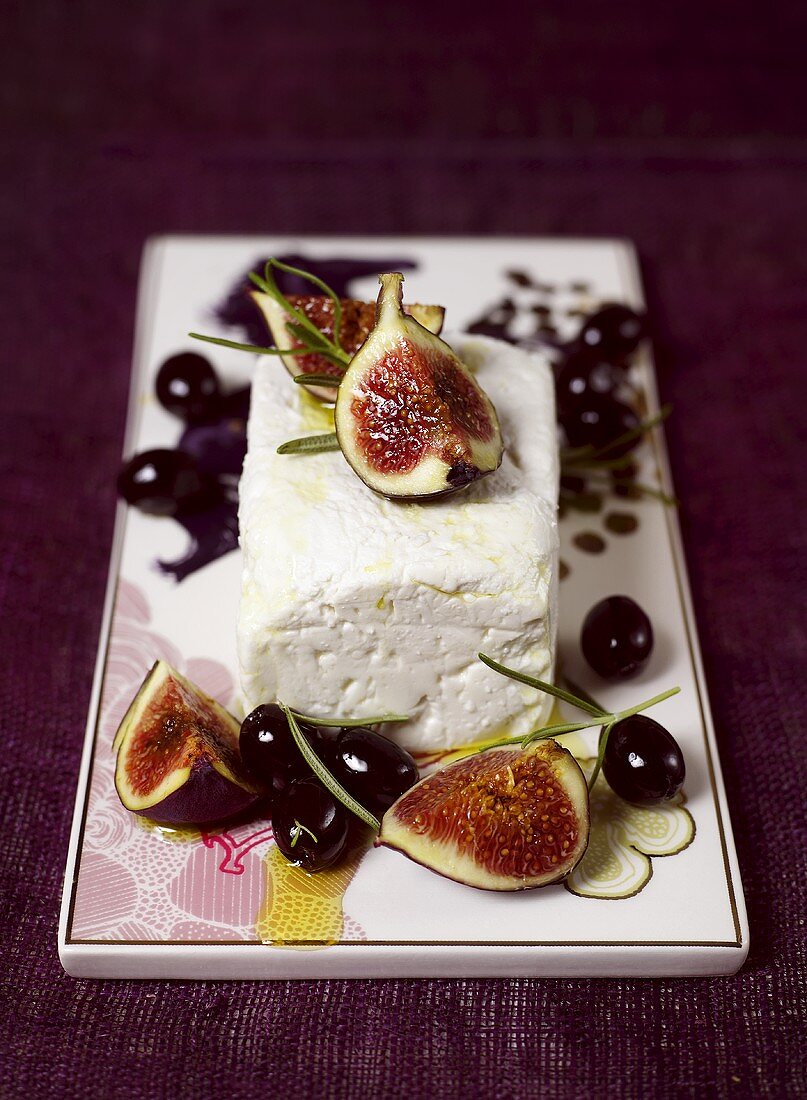 A piece of feta with black olives and figs