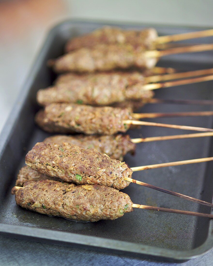 Oven-baked lamb kebabs on a baking tray