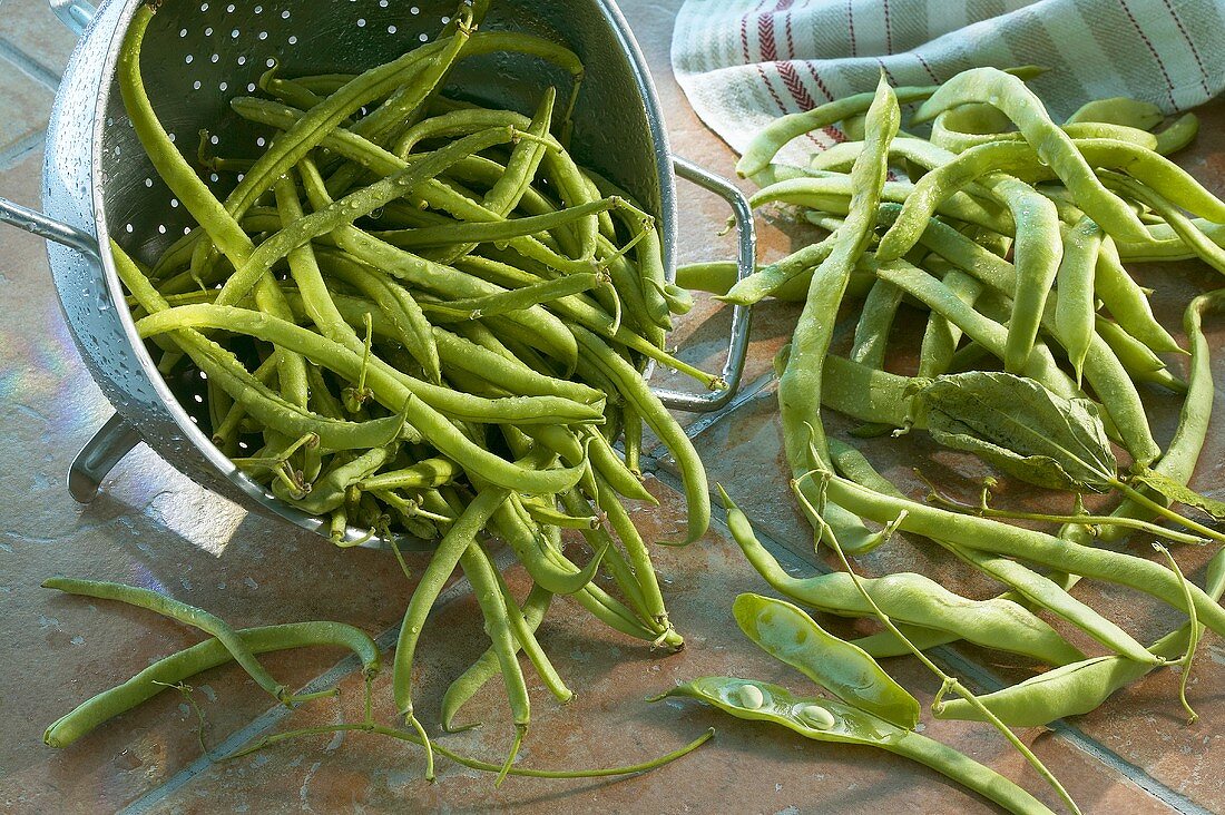Green beans in and beside colander