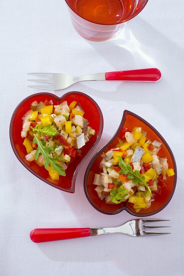 Herring salad in red heart-shaped dishes