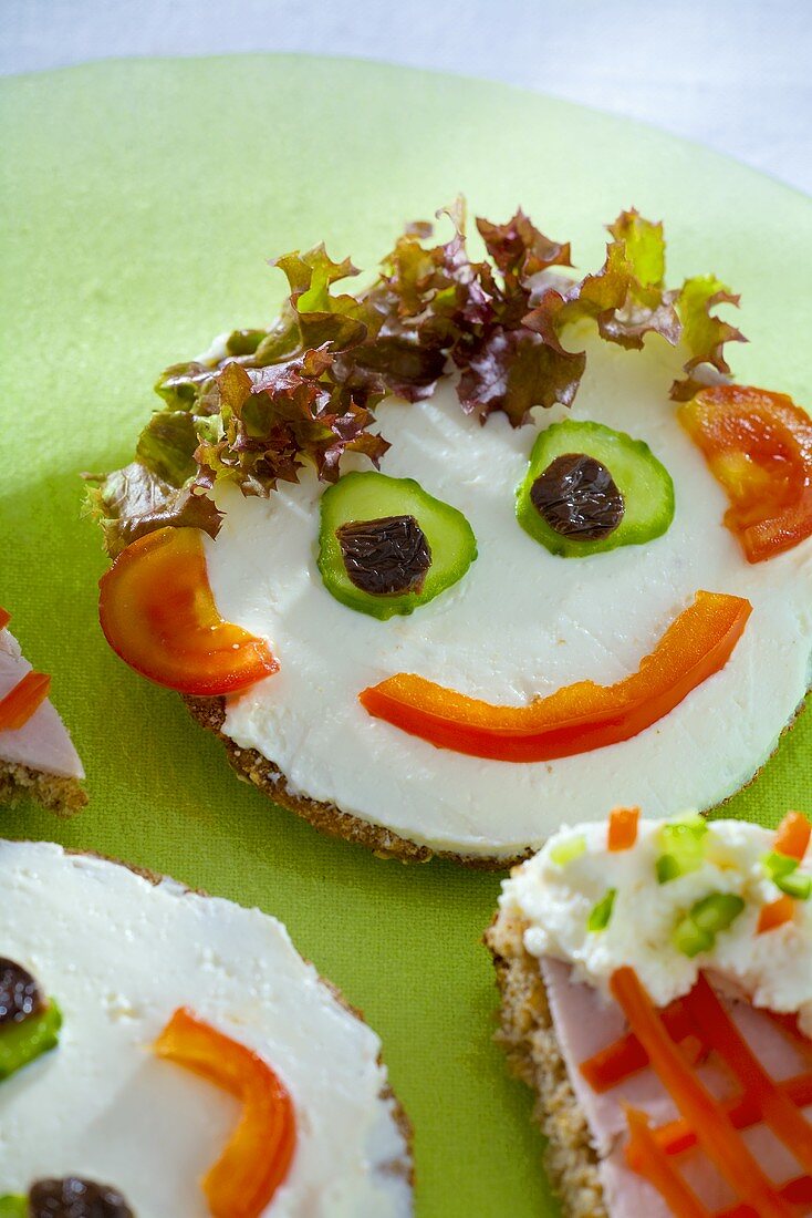 Soft cheese, salad & vegetables on wholemeal bread (a face)