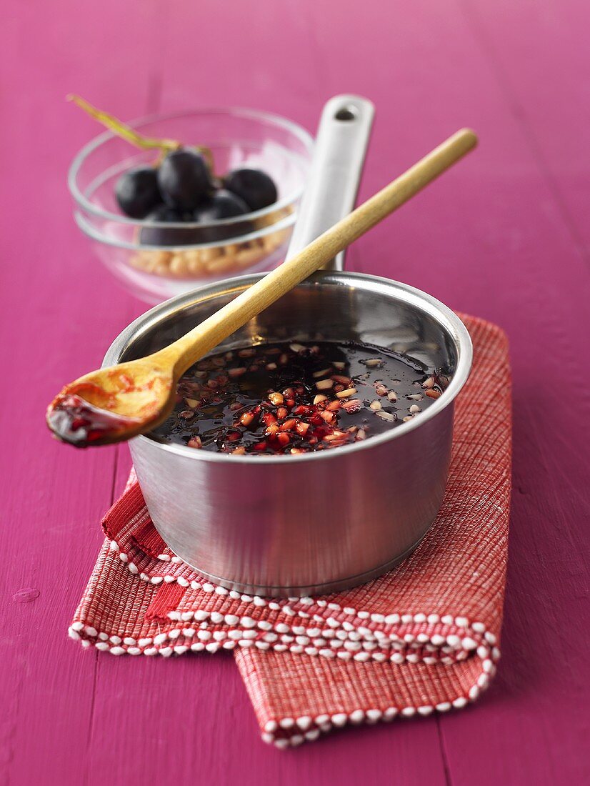 Red grape jelly with pine nuts in pan