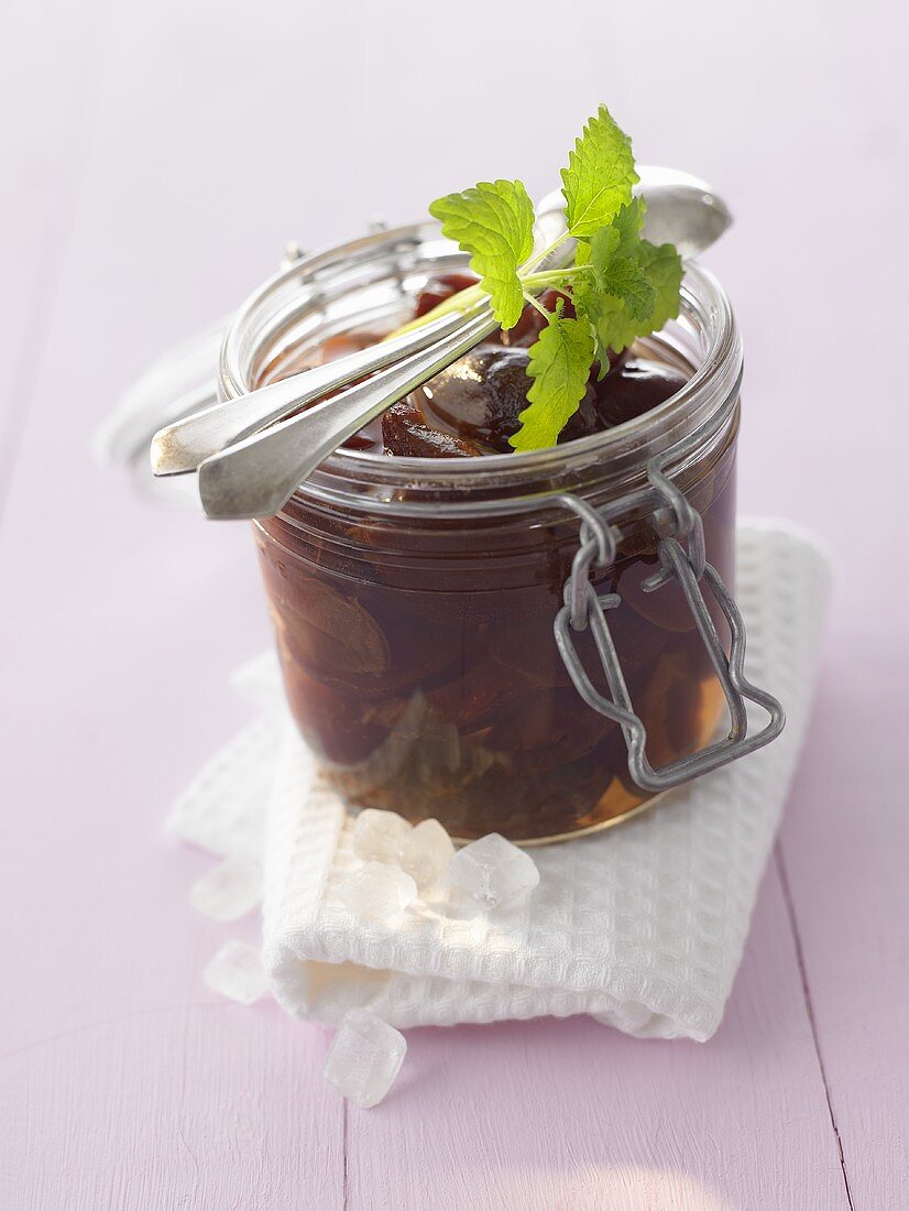 Plum compote with rum in a preserving jar