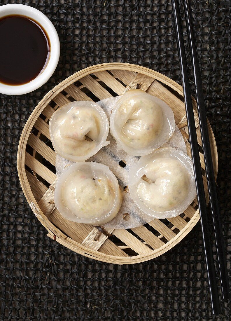 Dim sum in a bamboo basket with soy sauce