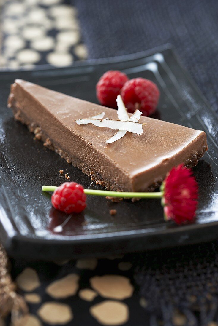 Piece of chocolate cake with coconut and raspberries