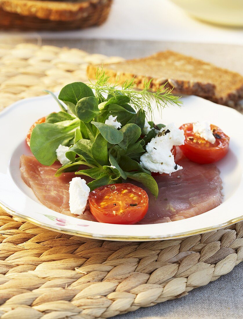 Tuna carpaccio with corn salad, soft cheese and tomatoes