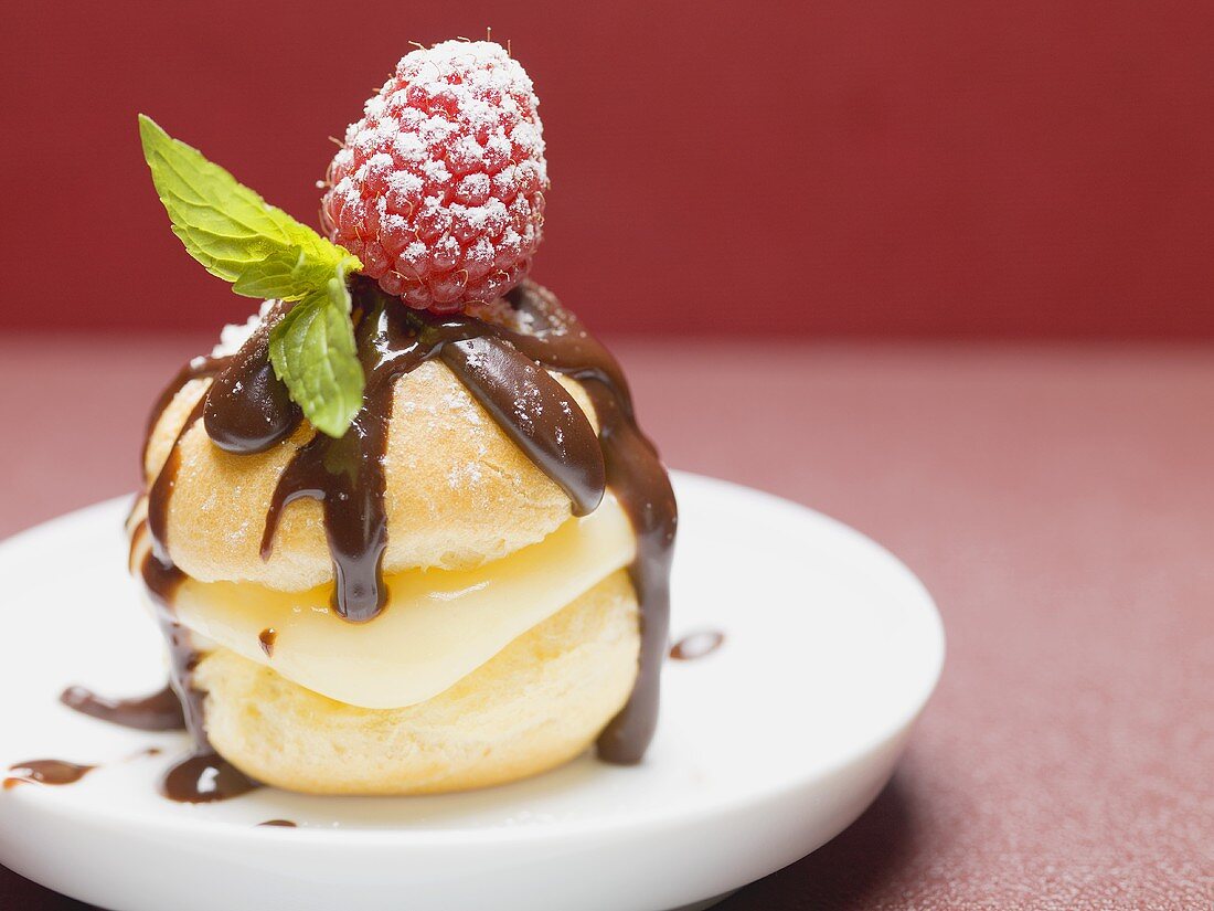 Profiterole with chocolate sauce, cream, raspberry & mint