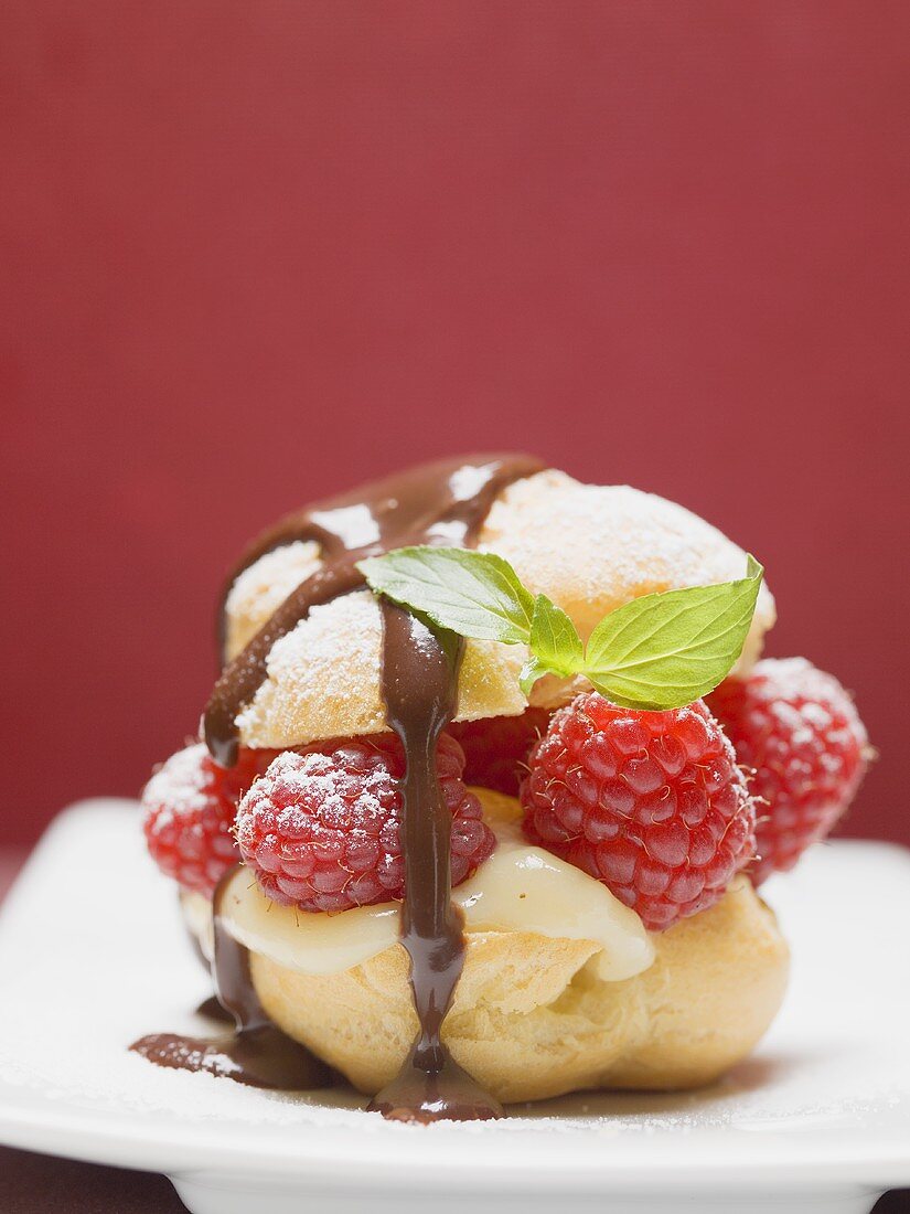 Profiterole with chocolate sauce, vanilla cream, raspberries & mint