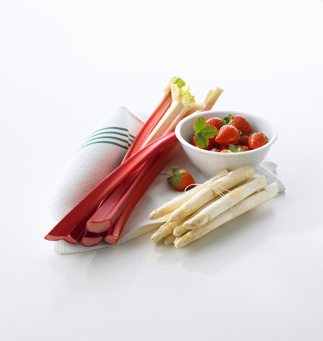 Rhubarb, strawberries and white asparagus on tea towel