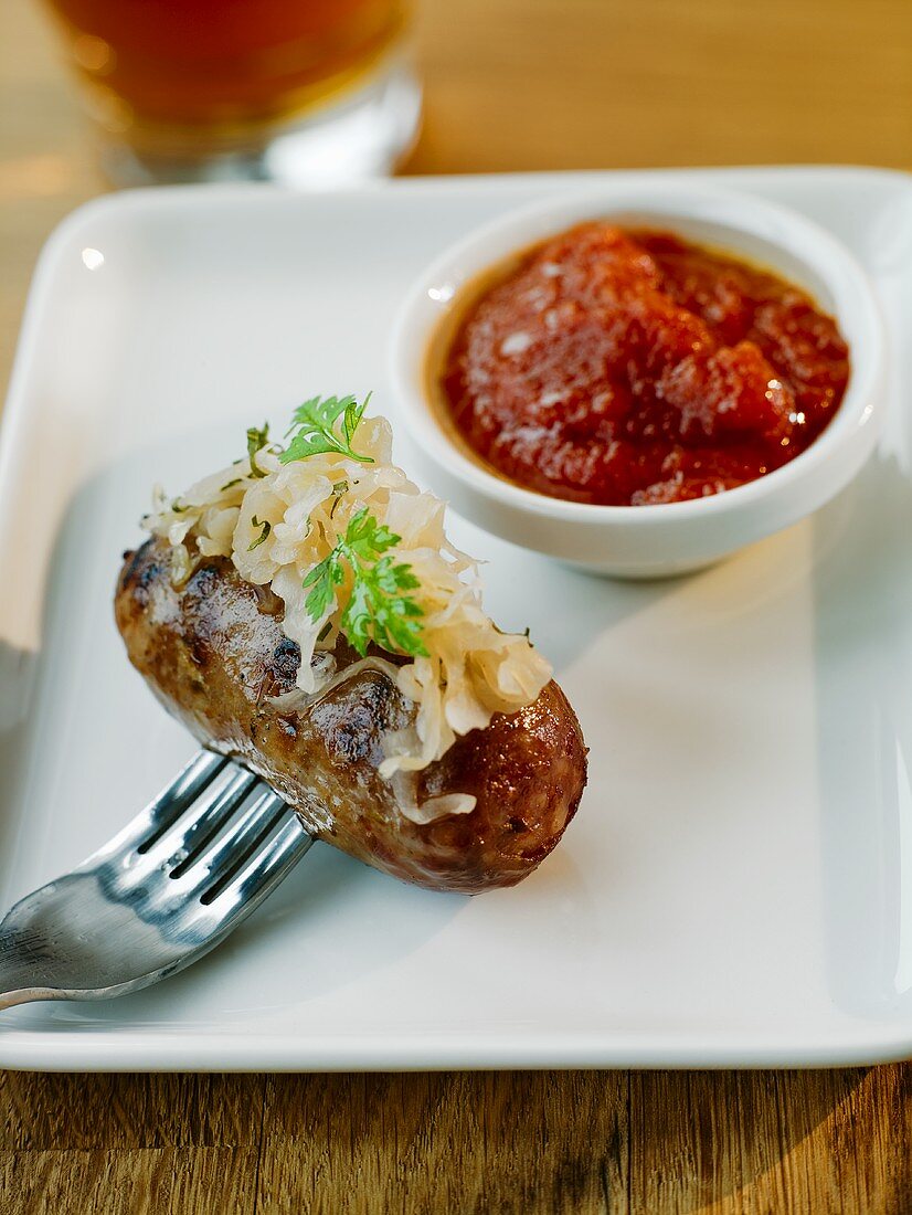 Gegrillte Wurst mit Sauerkraut und Tomatensauce