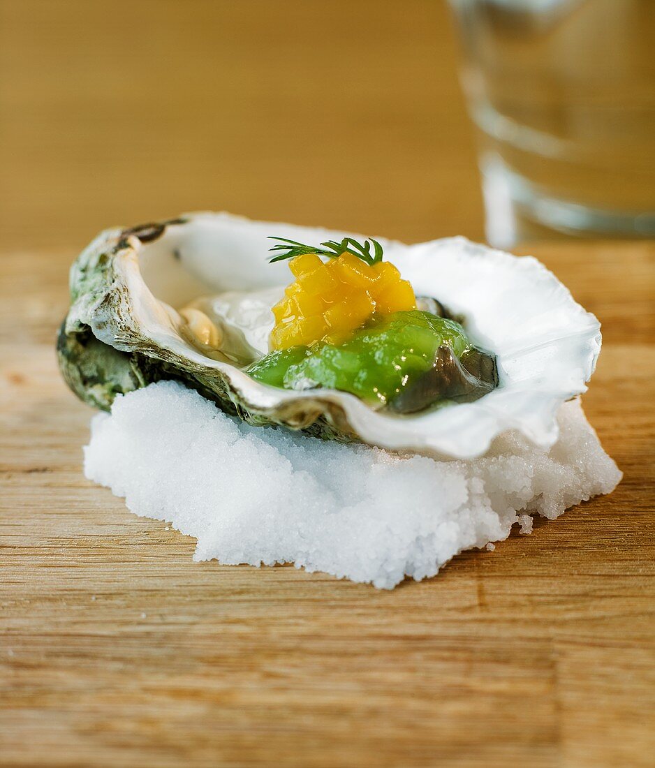 Oyster with cucumber and mango on a bed of salt