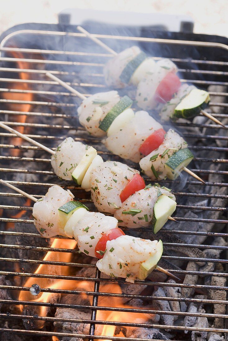 Fish and vegetable kebabs on a barbecue