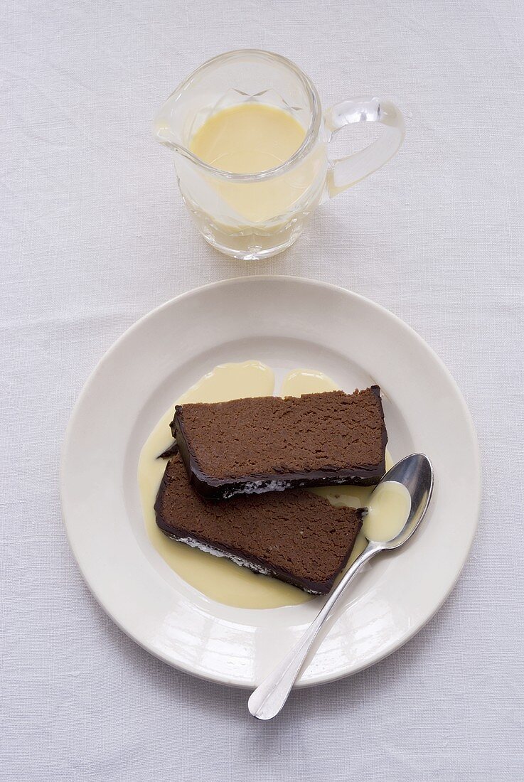 Zwei Stücke Schokoladenkuchen mit Vanillesauce