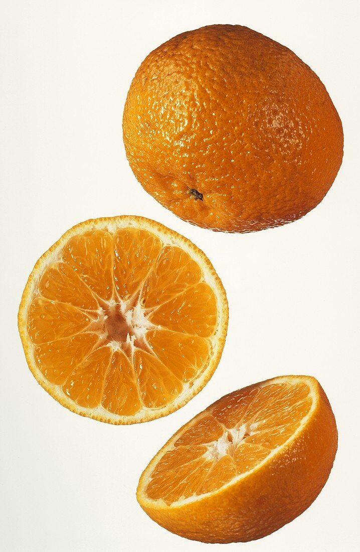Drei halbe Clementinen vor weißem Hintergrund