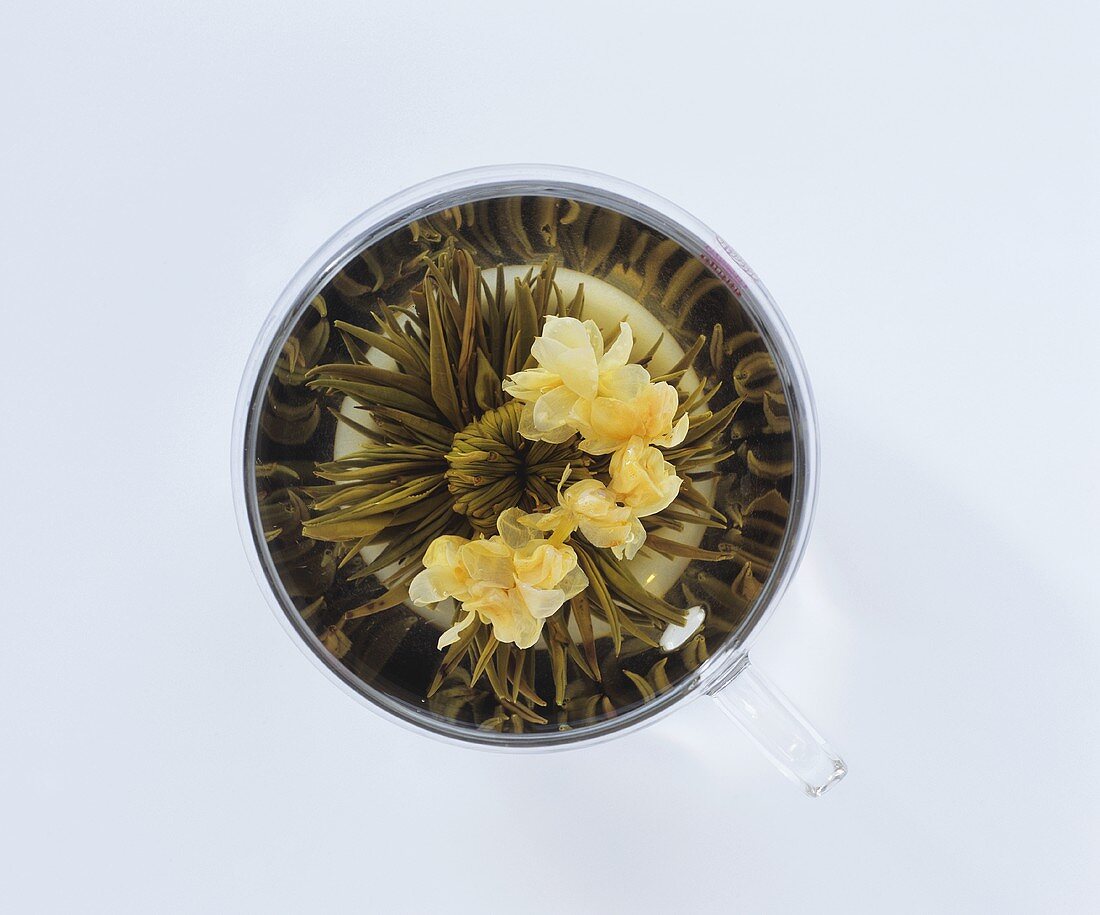 Teerose mit Blüten in einer Glastasse