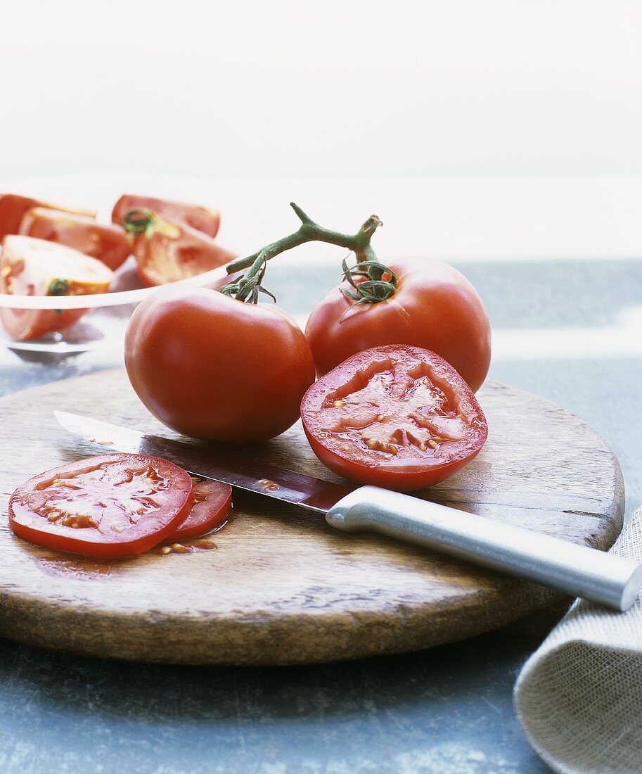 Vine tomatoes on chopping board with knife