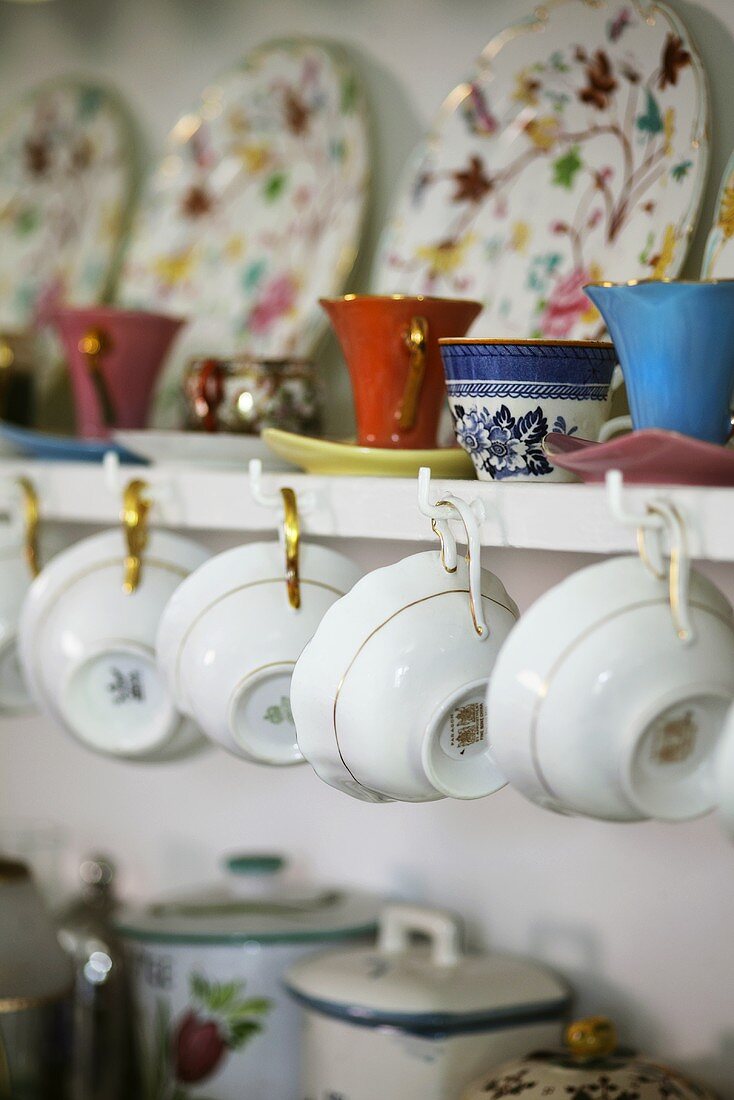 Cups and plates on a wall shelf in a kitchen