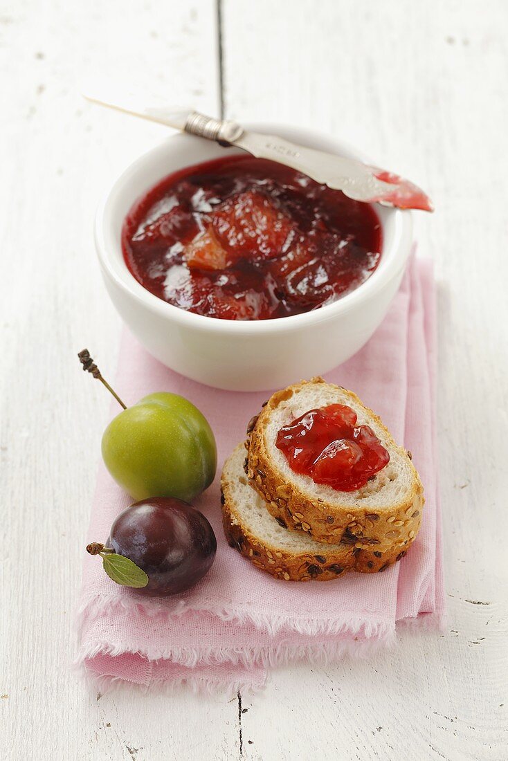 Plum jam in a bowl and on bread