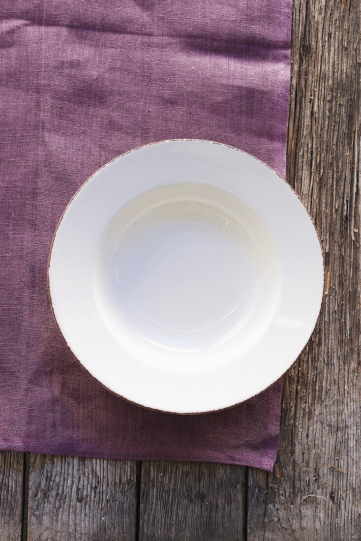 An empty plate on a purple cloth