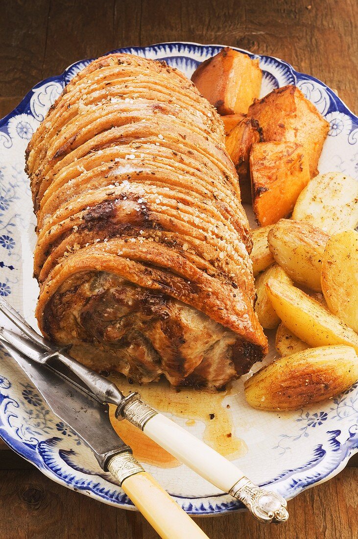 Roast pork with a side of vegetables on a serving platter