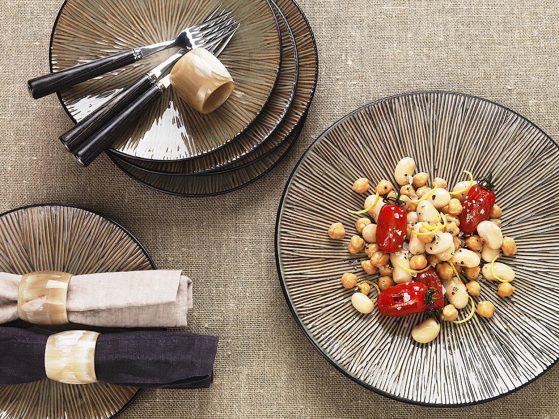 Looking down onto a stripped plate, oriental, with preserved tomatoes and chickpeas