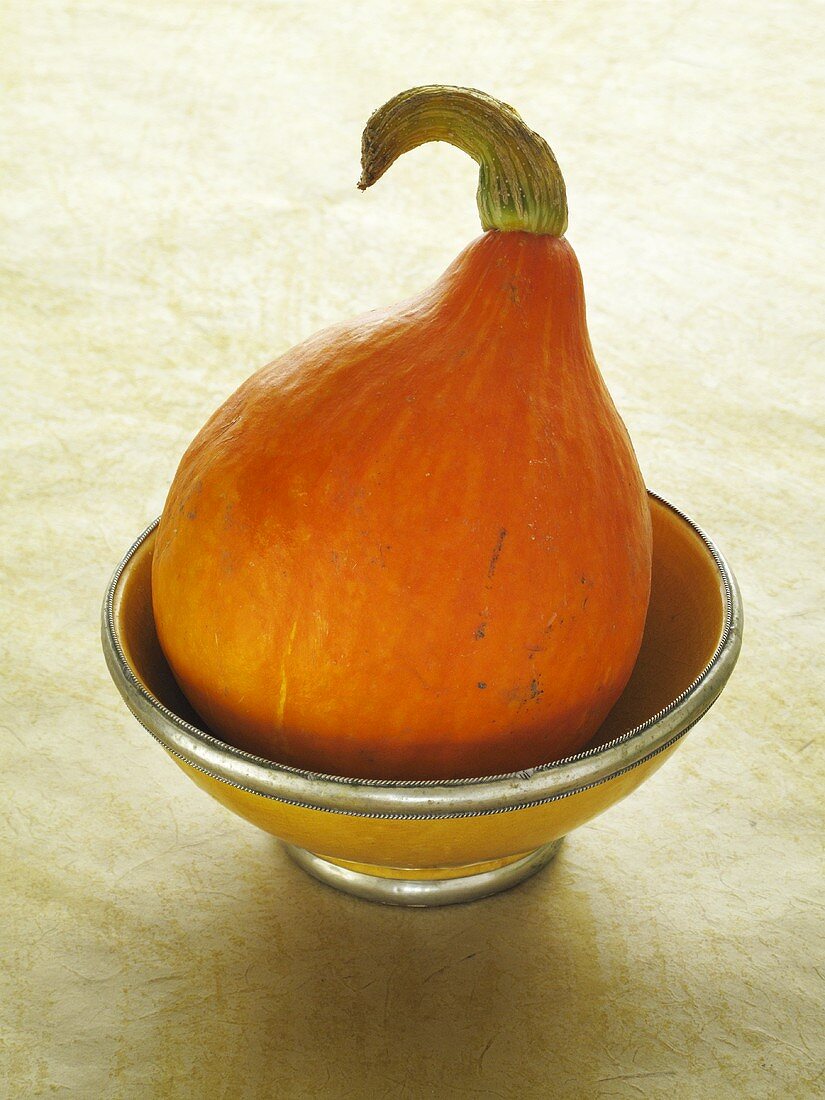 An orange pumpkin in a bowl