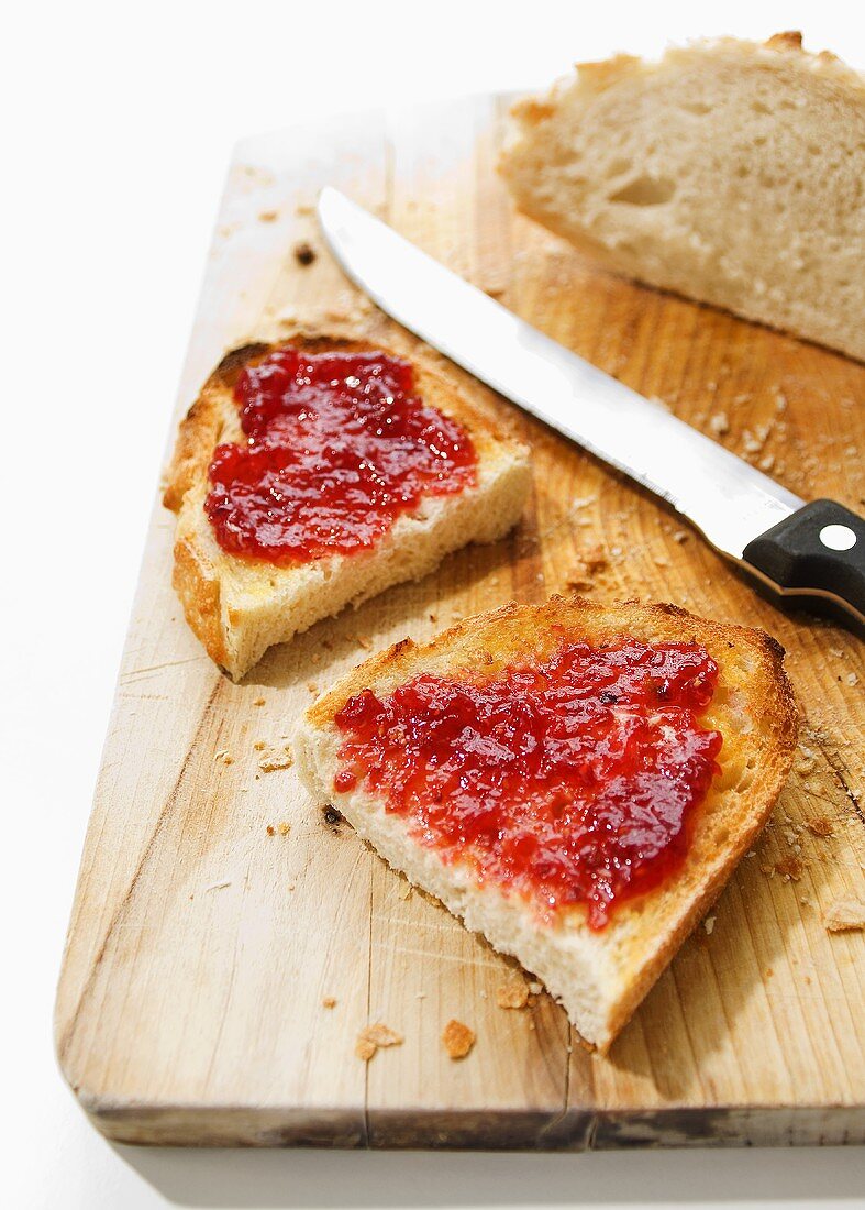 Toasted white bread with jam on a chopping board