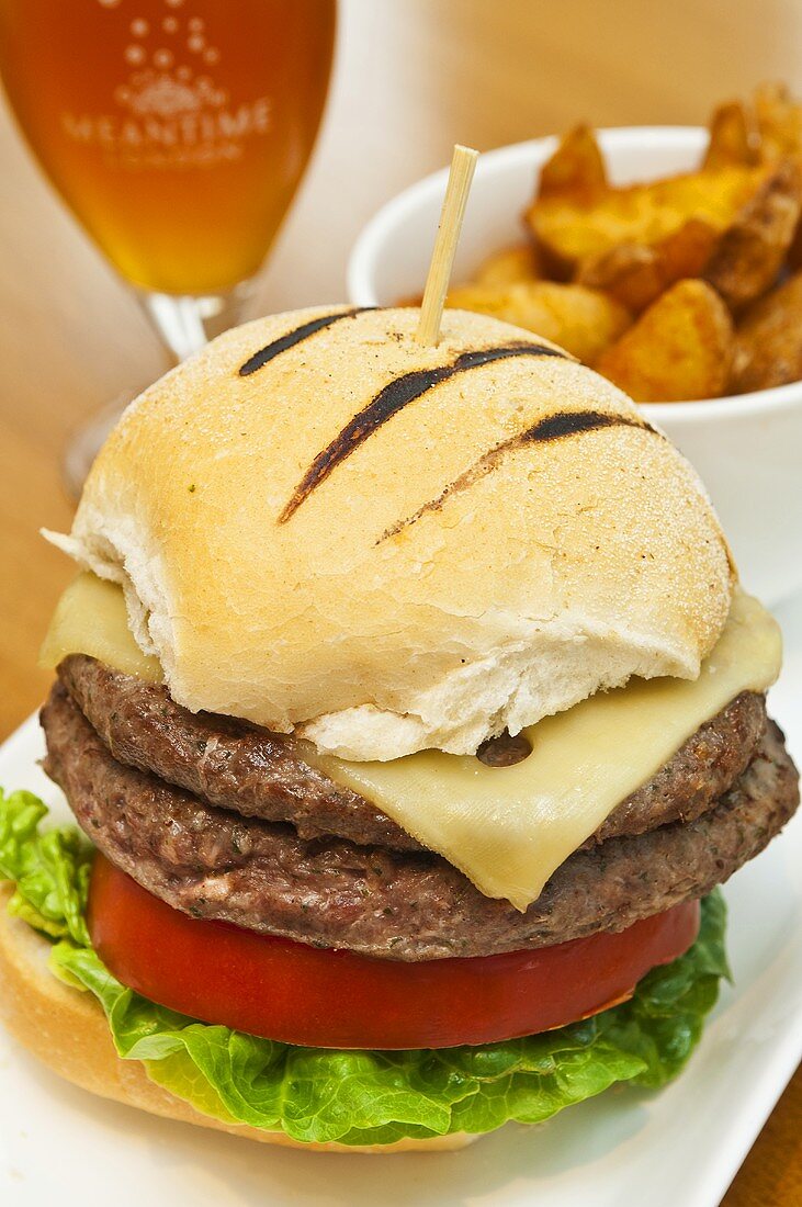 A cheeseburger with chips and beer