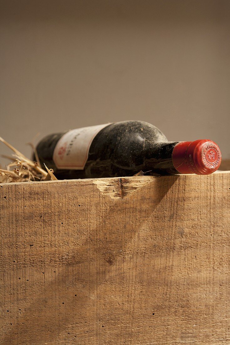 Rotweinflasche mit Etikett auf Holzkiste