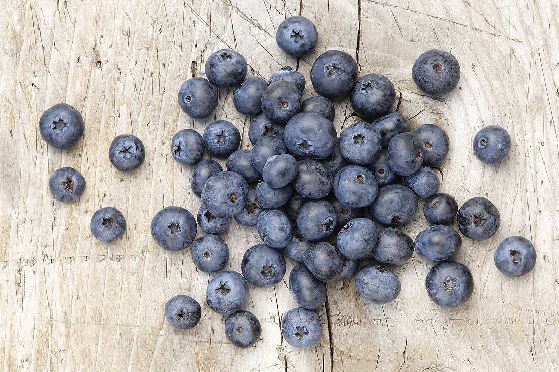 Viele Heidelbeeren auf Holzuntergrund von oben