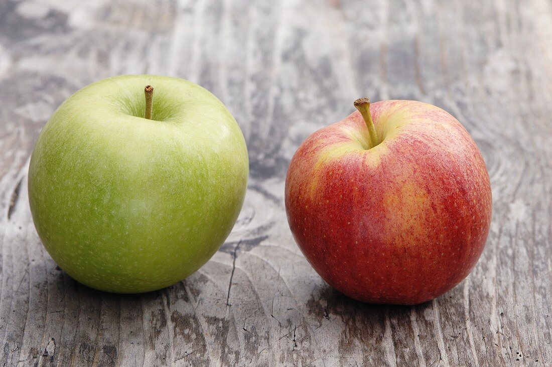 Two apples (Granny Smith and Elstar) on a wooden surface