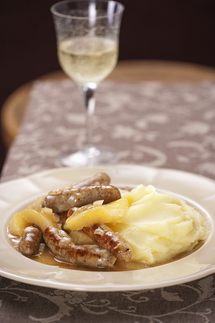 Bratwürstchen mit Äpfeln in Weinsauce und Kartoffelpüree