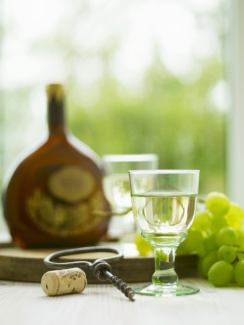 White wine with grapes and an antique corkscrew