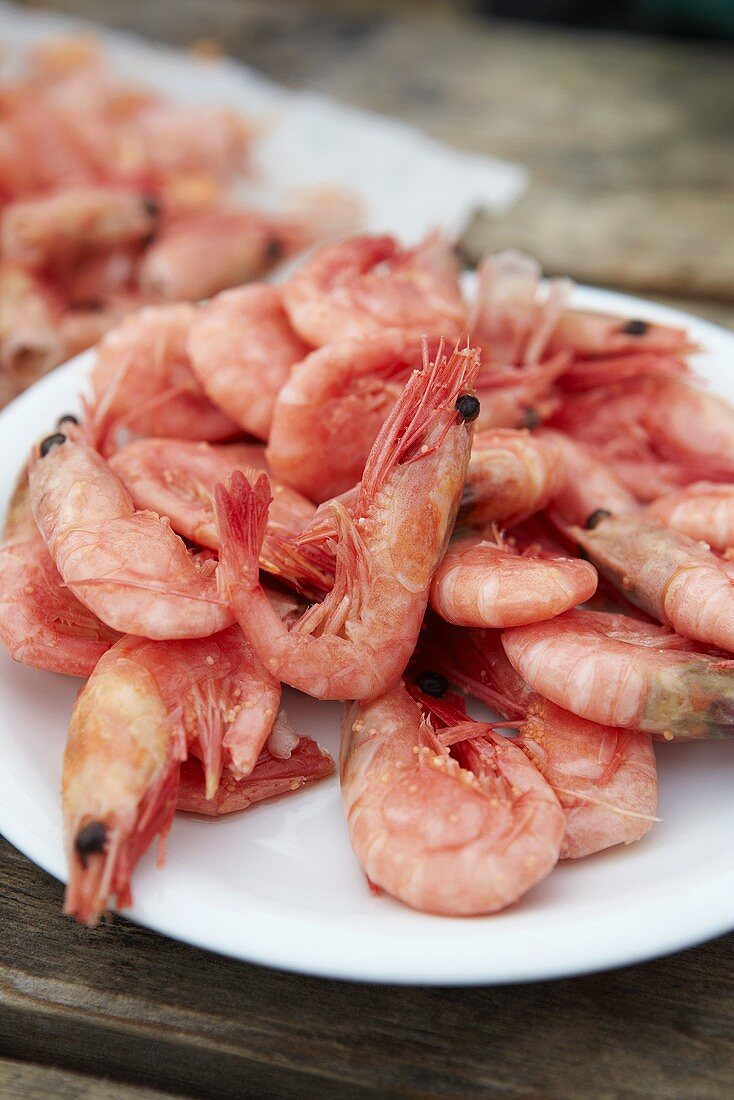 A plate of cooked, shelled prawns