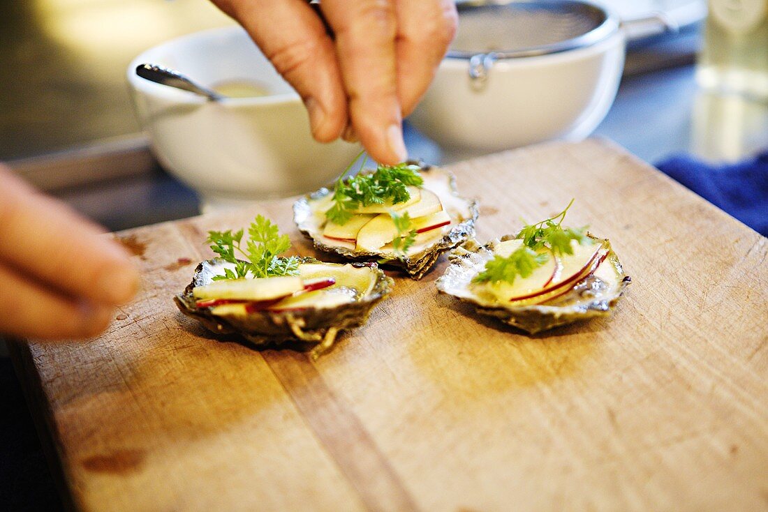 Arranging oysters with apples and herbs
