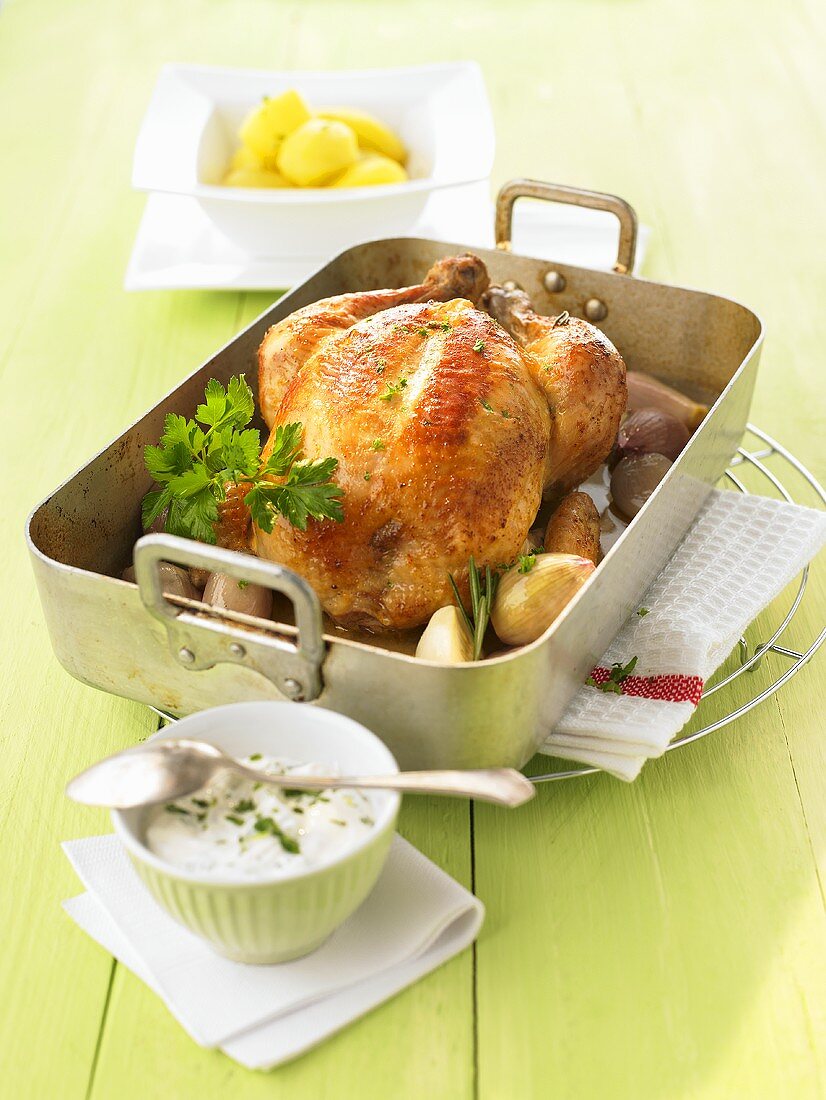 Roast chicken with shallots in a roasting tin