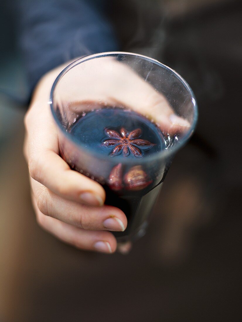 A hand holding a glass of mulled wine
