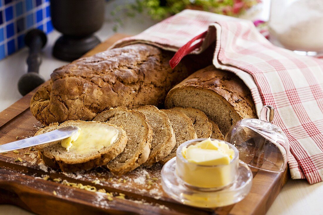 Brotscheibe mit Butter bestreichen