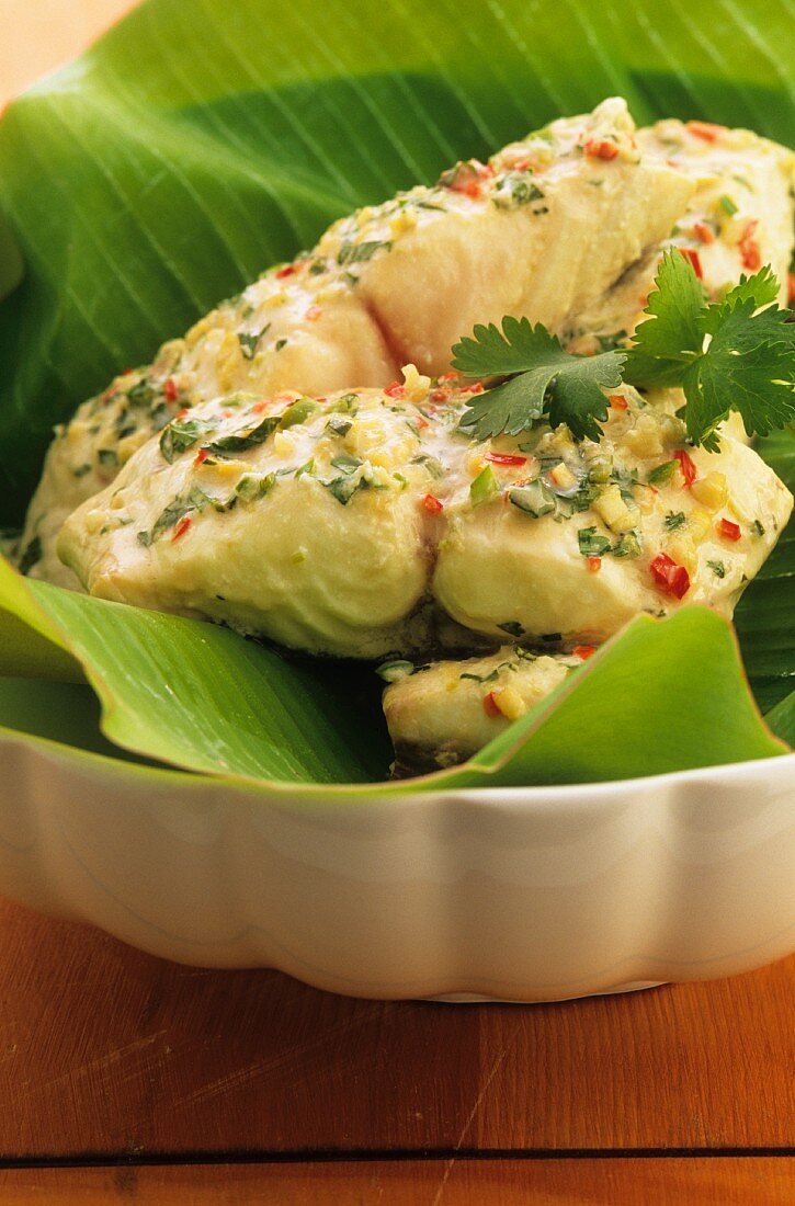 Fish fillet in coconut milk on a banana leaf