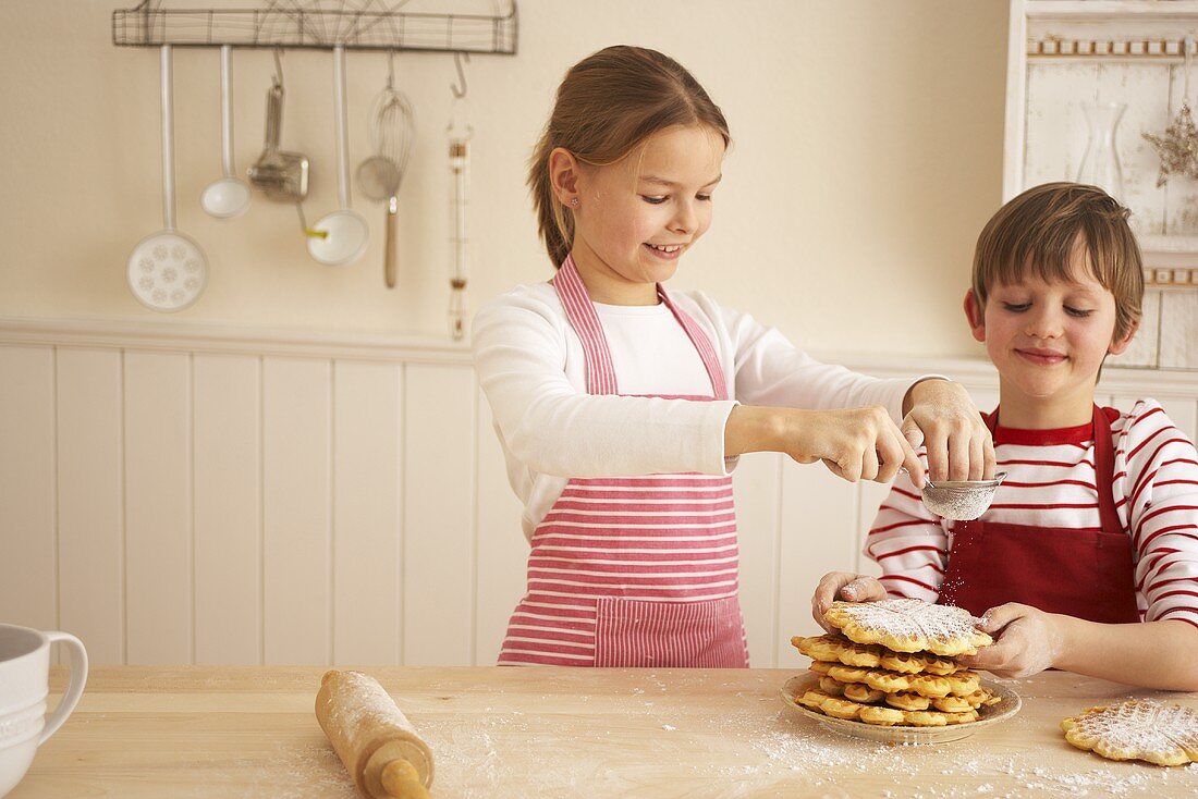 Two children baking waffles for advent