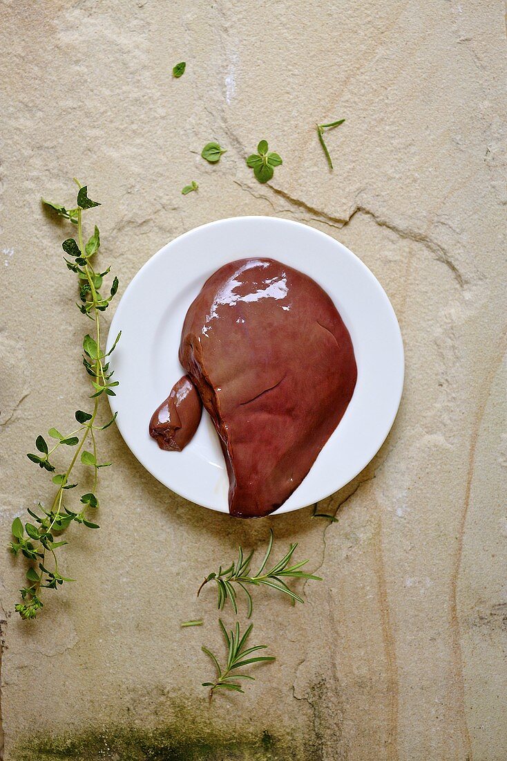Raw lamb liver on a plate, seen from above