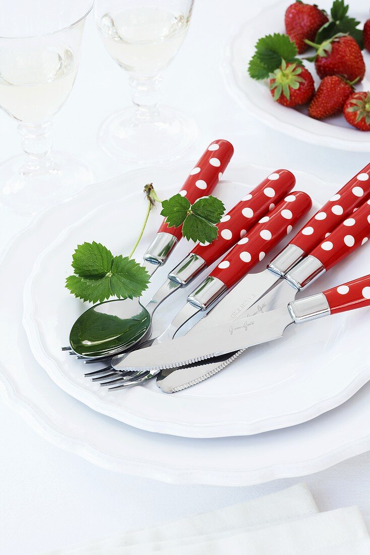 Red and white polka dot cutlery on a plate