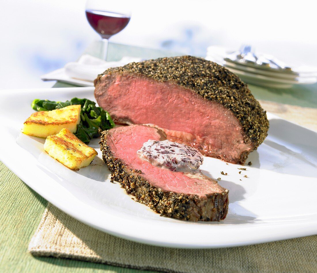 Roast beef with a pepper crust with herb butter and polenta